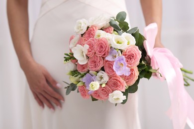 Photo of Bride with beautiful wedding bouquet on light background, closeup