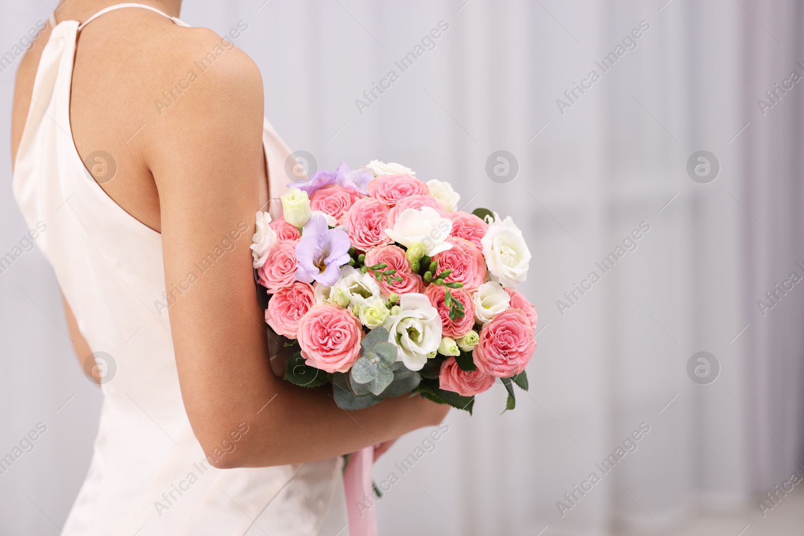 Photo of Bride with beautiful wedding bouquet on light background, closeup. Space for text