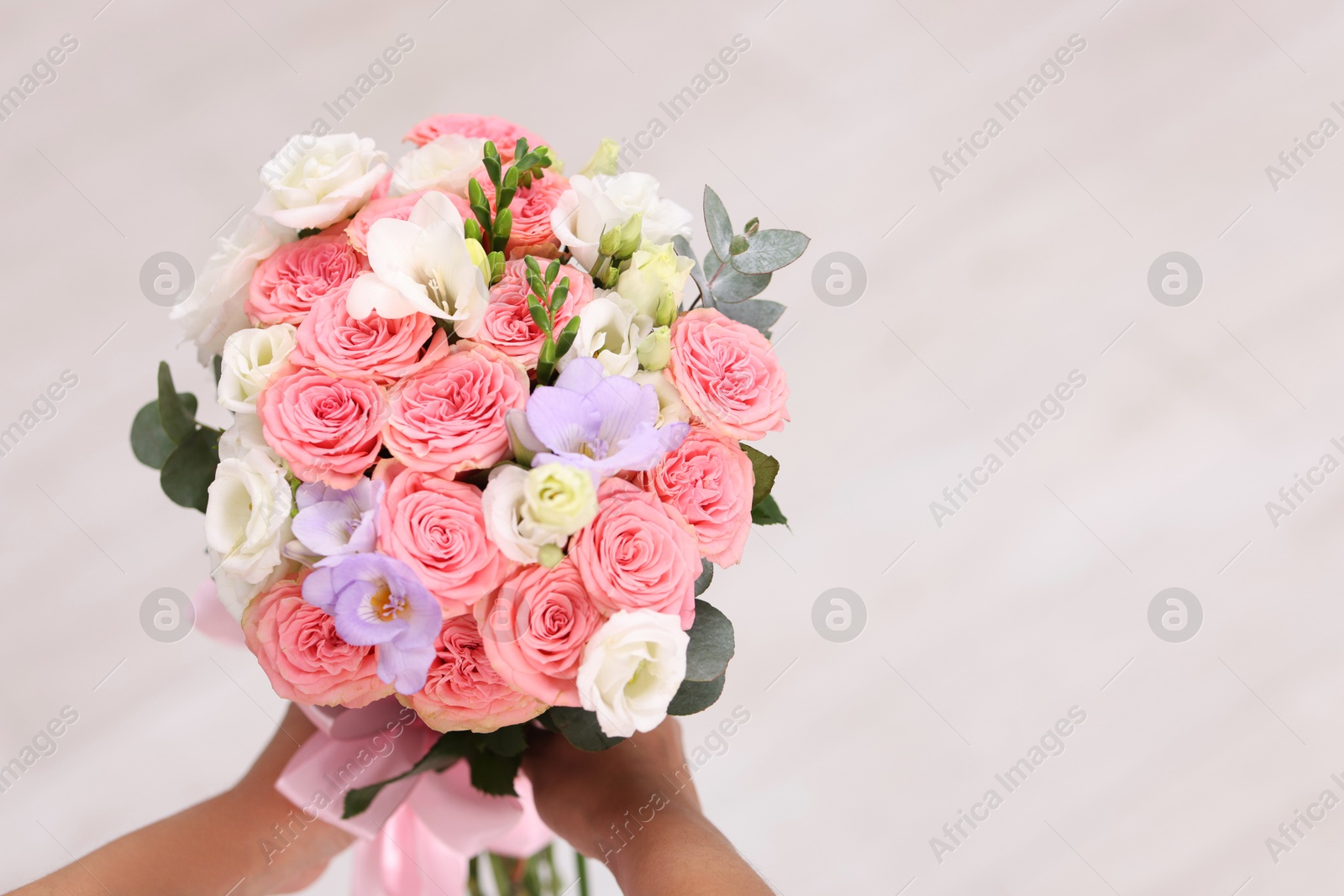 Photo of Bride with beautiful wedding bouquet on light background, closeup. Space for text