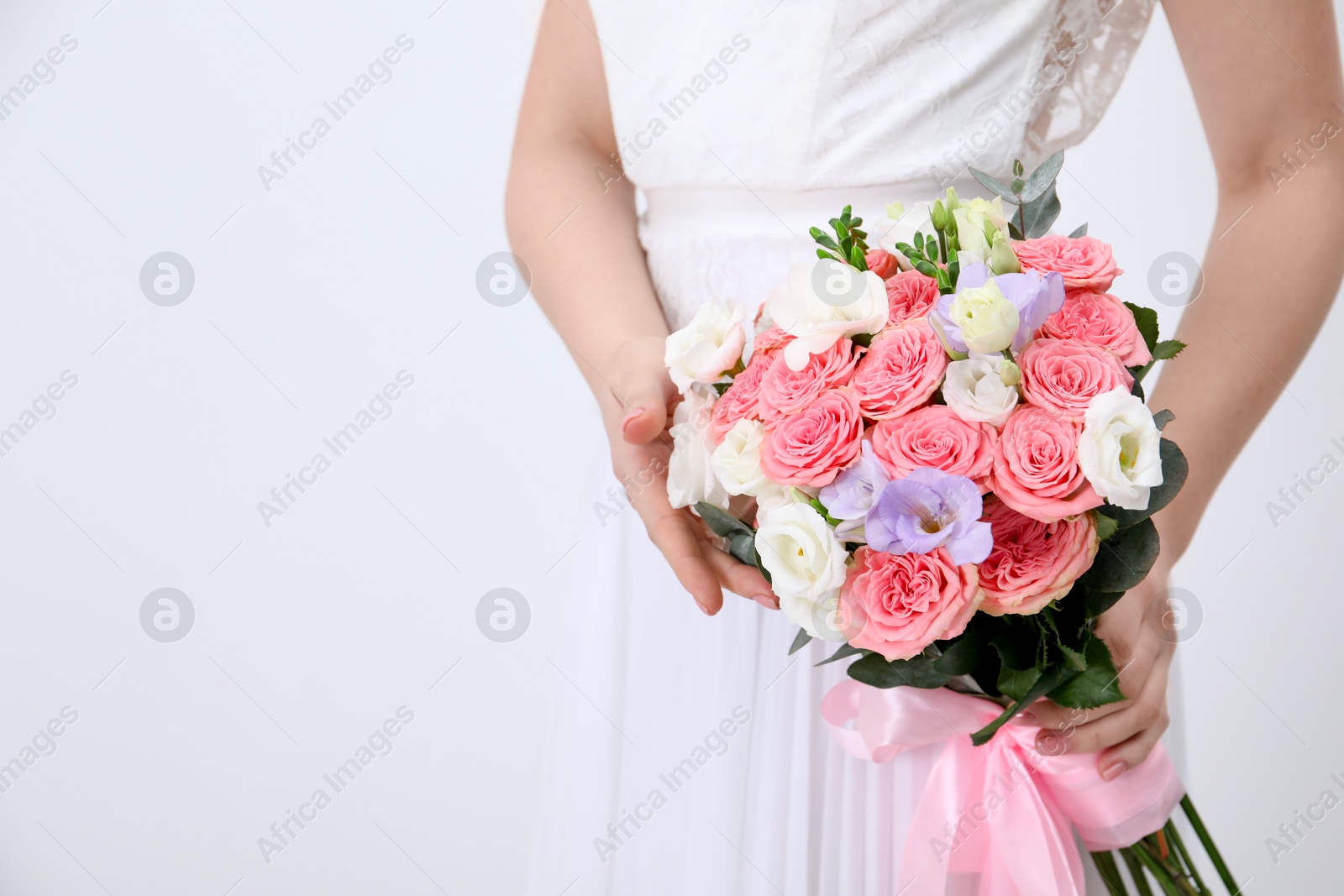 Photo of Bride with beautiful wedding bouquet on light background, closeup. Space for text