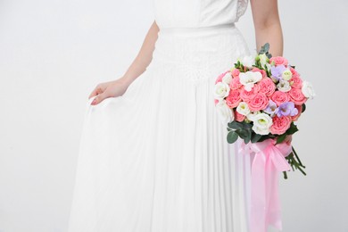 Photo of Bride with beautiful wedding bouquet on light background, closeup