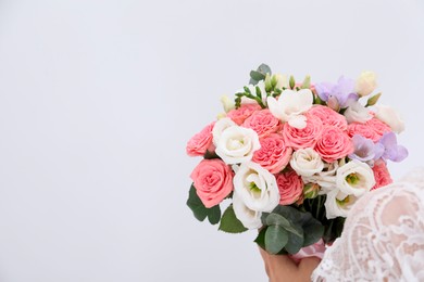 Photo of Bride with beautiful wedding bouquet on light background, closeup. Space for text