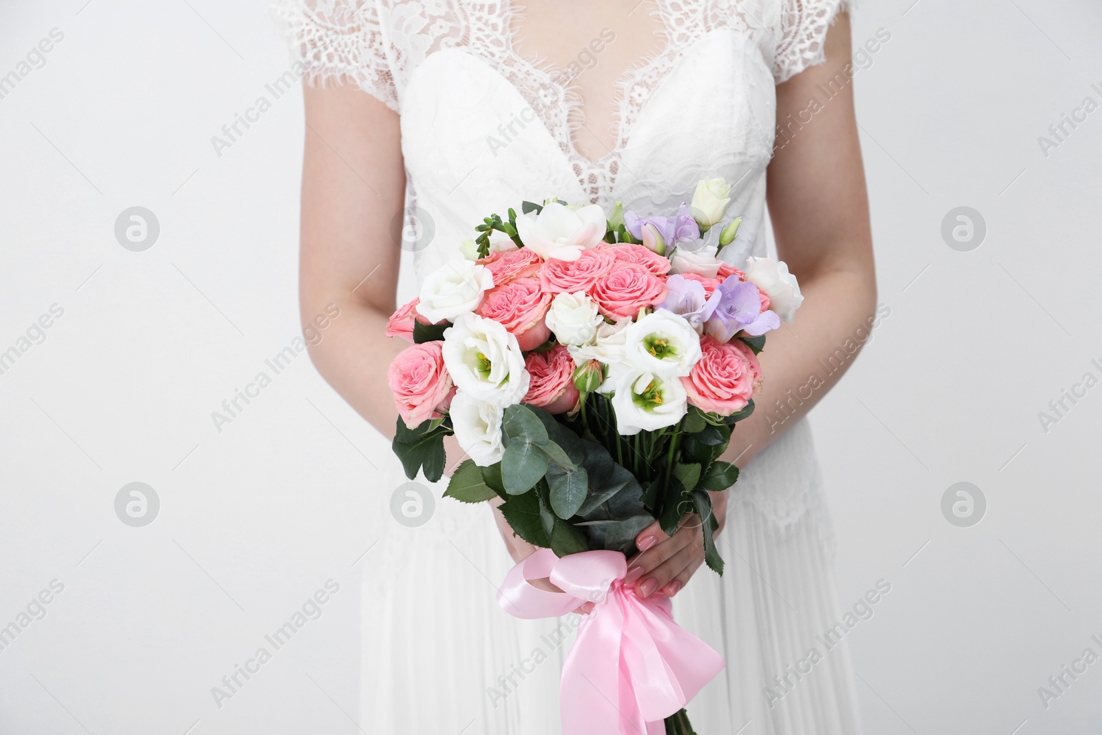 Photo of Bride with beautiful wedding bouquet on light background, closeup