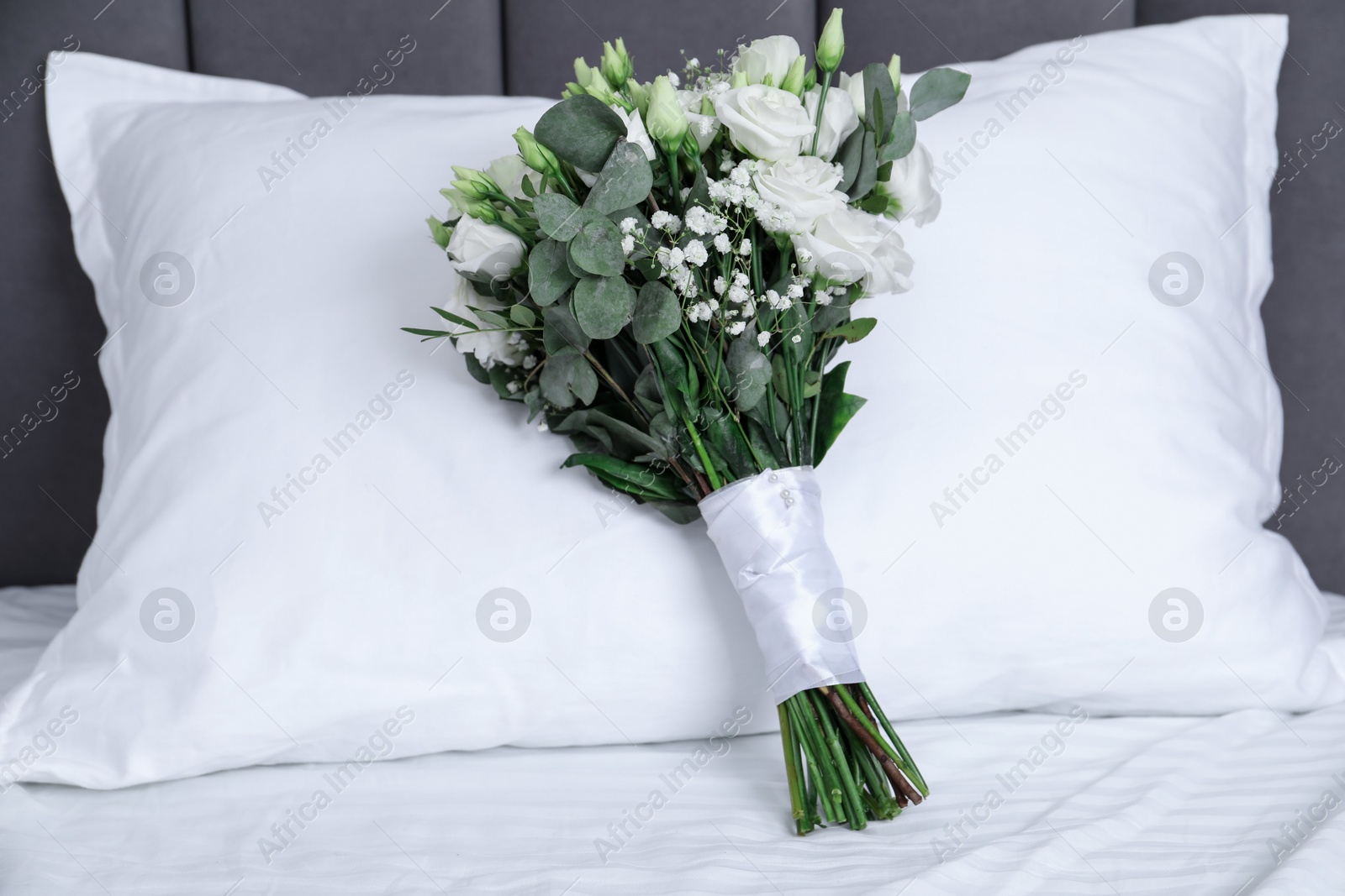 Photo of Wedding bouquet of beautiful flowers and pillow on bed