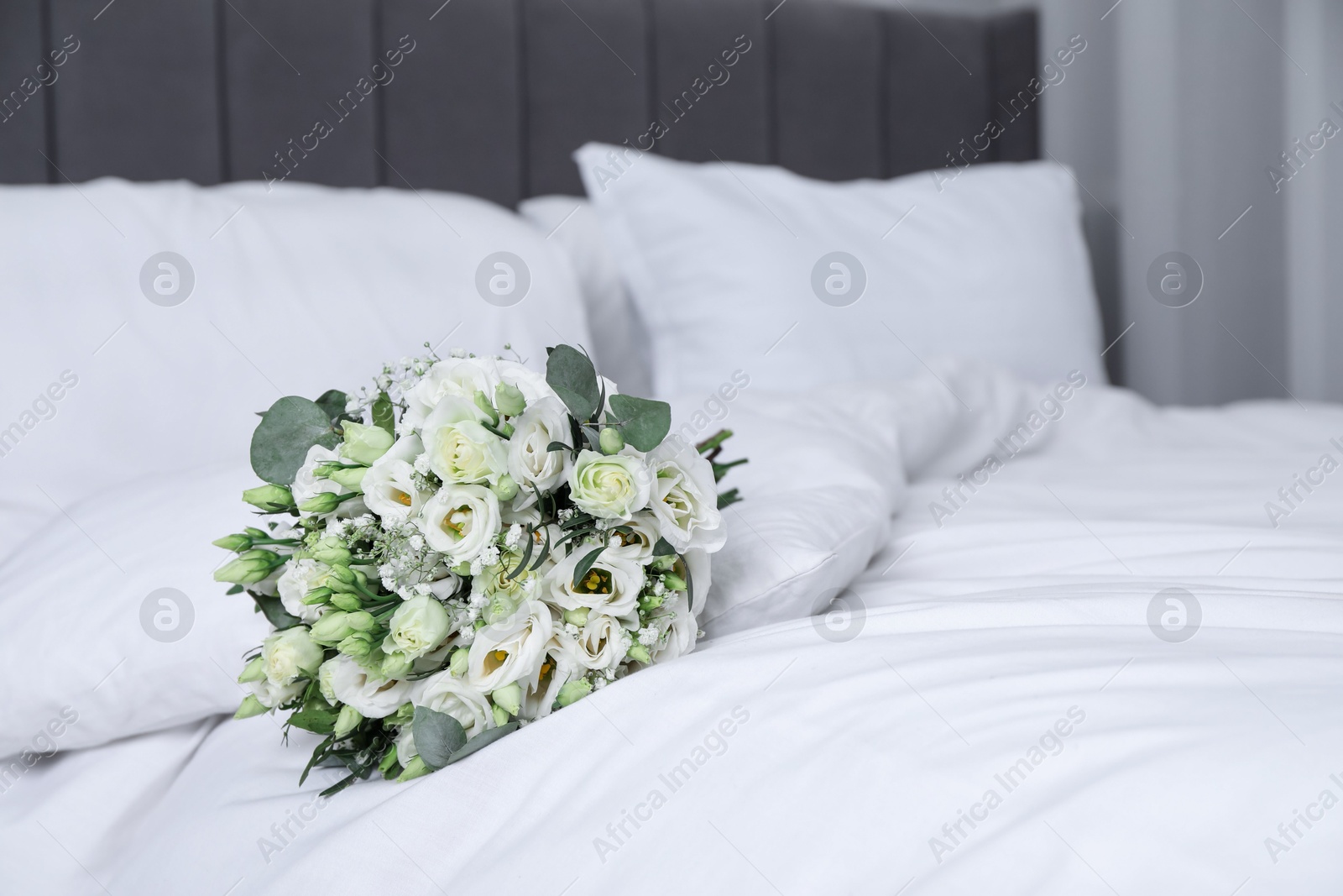 Photo of Wedding bouquet of beautiful flowers on bed indoors, closeup. Space for text