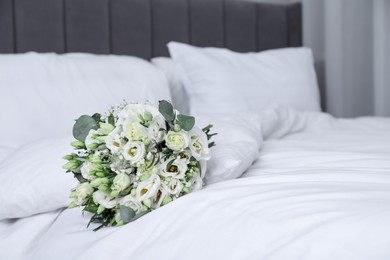 Photo of Wedding bouquet of beautiful flowers on bed indoors, closeup. Space for text