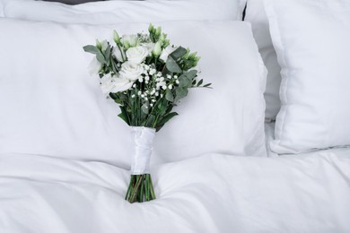 Photo of Wedding bouquet of beautiful flowers and pillows on bed