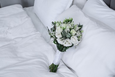 Photo of Wedding bouquet of beautiful flowers and pillows on bed