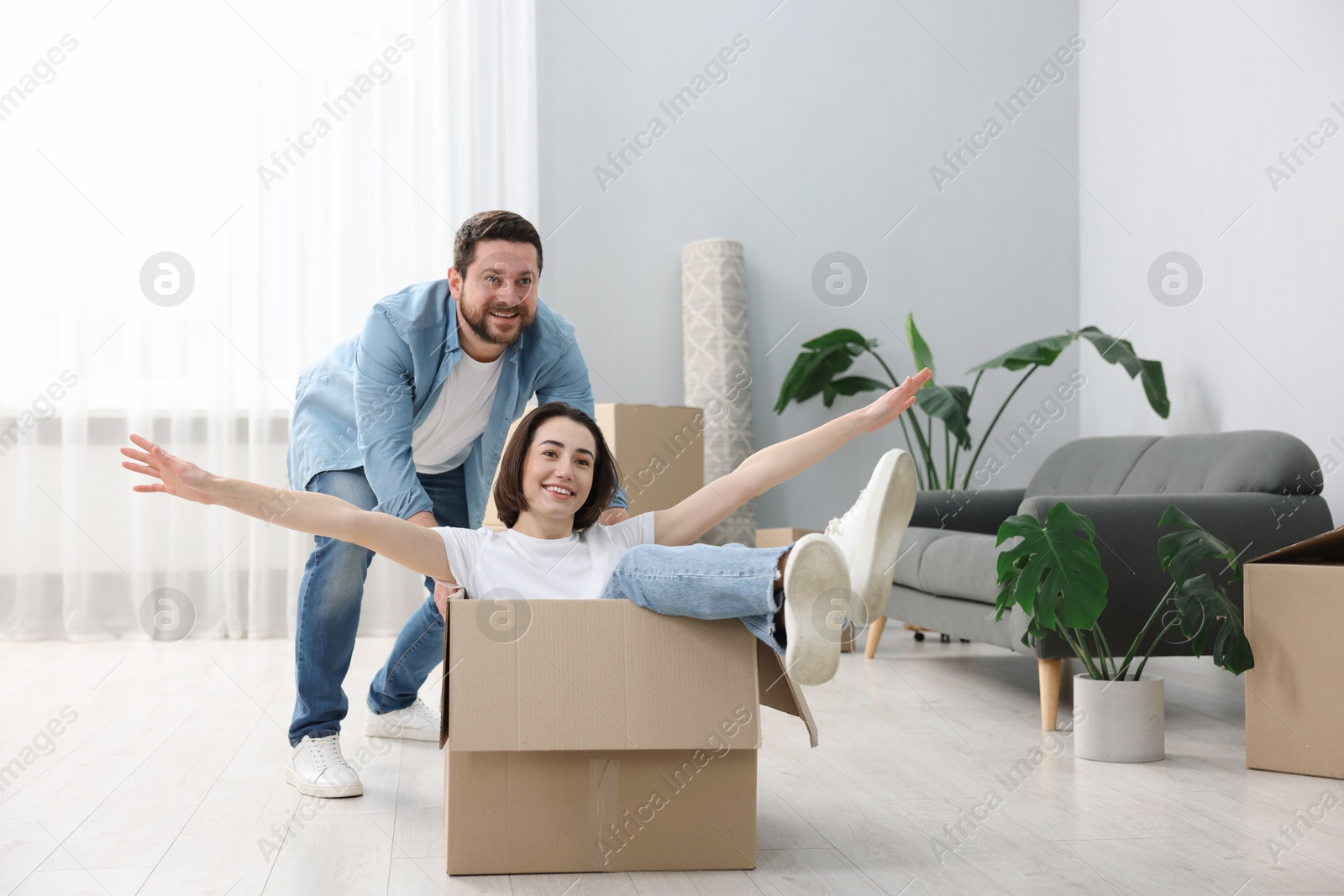 Photo of Moving day. Happy couple having fun in their new home