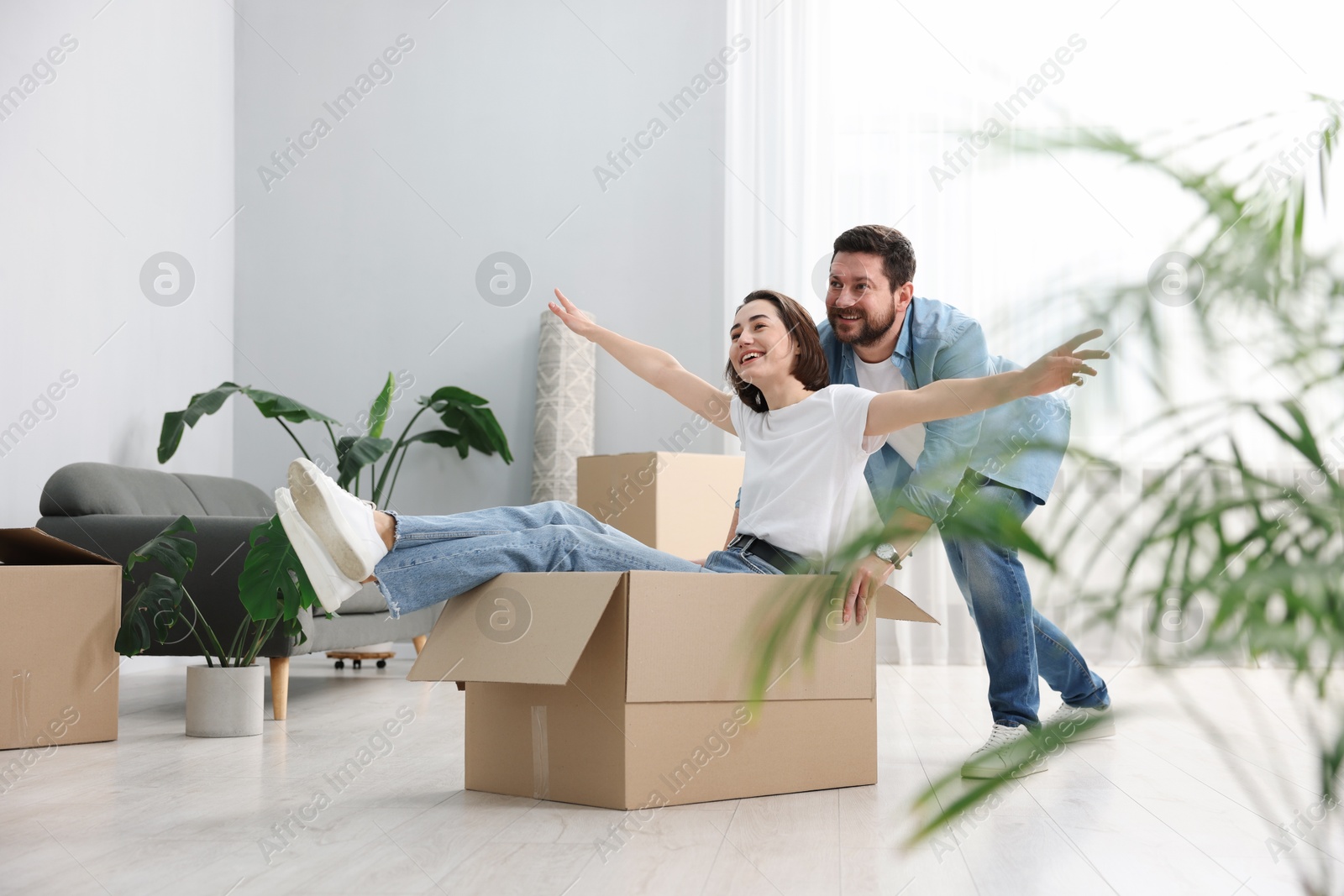 Photo of Moving day. Happy couple having fun in their new home