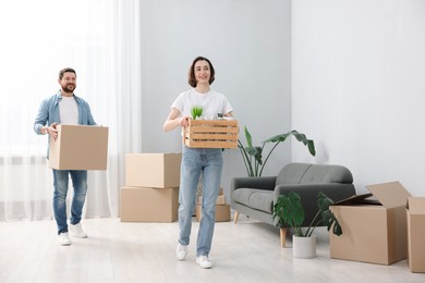 Photo of Moving day. Happy couple with boxes in their new home