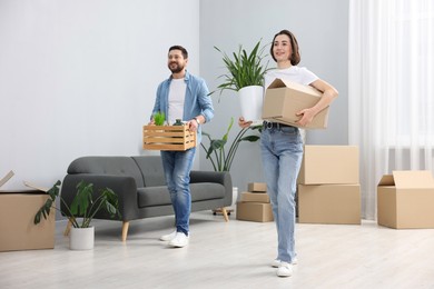 Photo of Moving day. Happy couple with boxes in their new home