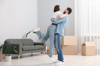 Photo of Moving day. Happy couple dancing in their new home