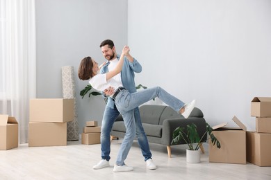 Photo of Moving day. Happy couple dancing in their new home