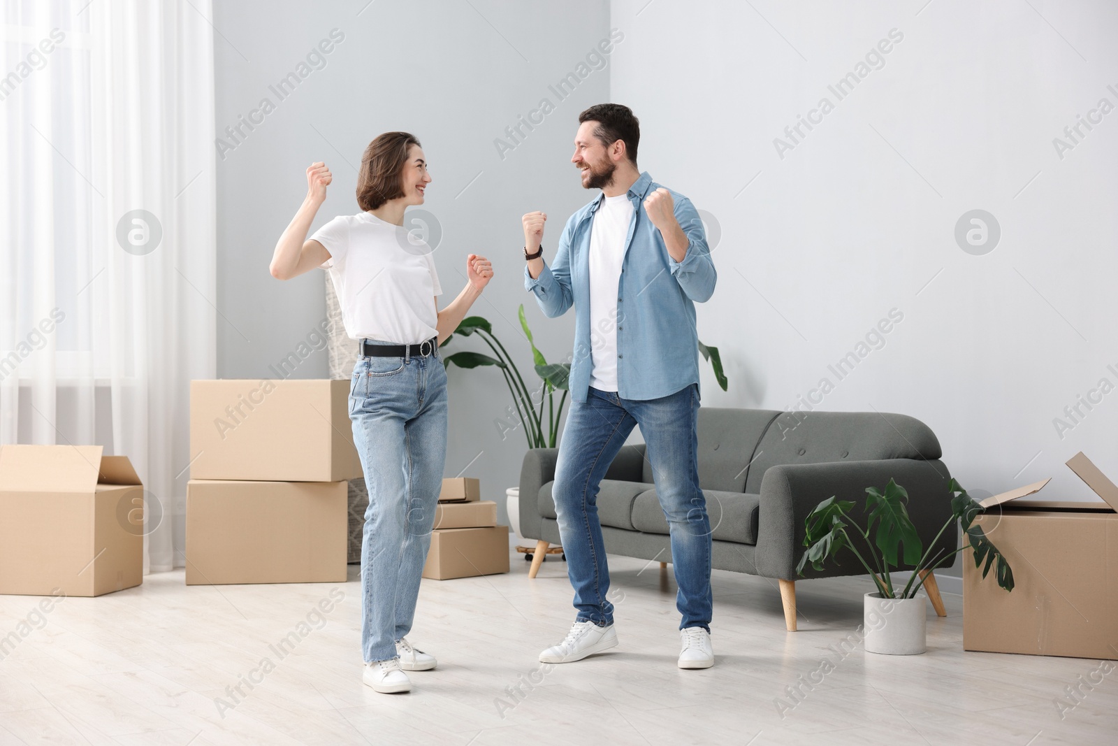 Photo of Moving day. Happy couple dancing in their new home