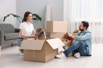 Moving day. Happy couple unpacking their belongings in new home