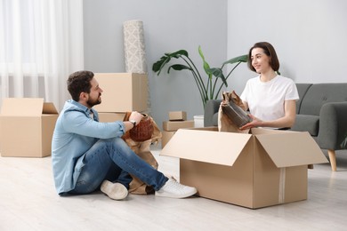 Photo of Moving day. Happy couple unpacking their belongings in new home