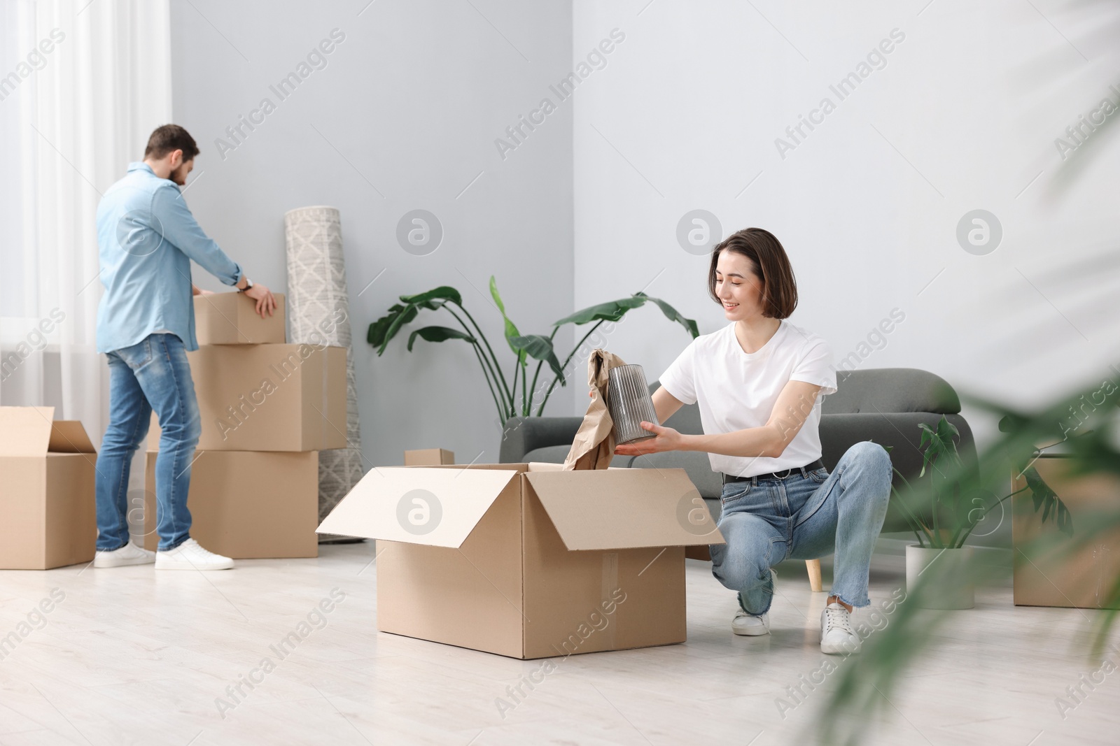 Photo of Moving day. Happy couple unpacking their belongings in new home, selective focus