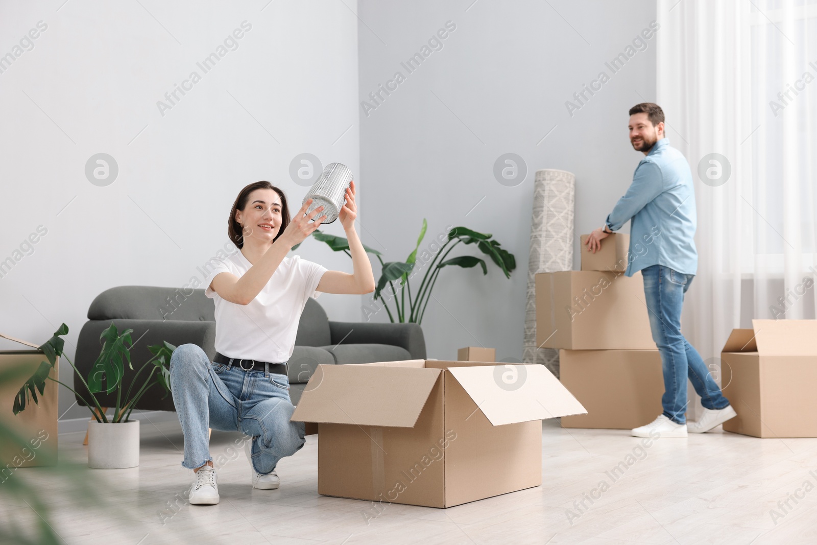 Photo of Moving day. Happy couple unpacking their belongings in new home, selective focus