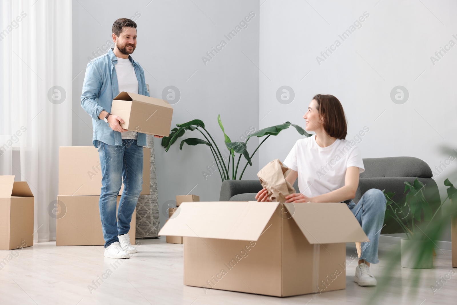 Photo of Moving day. Happy couple unpacking their belongings in new home