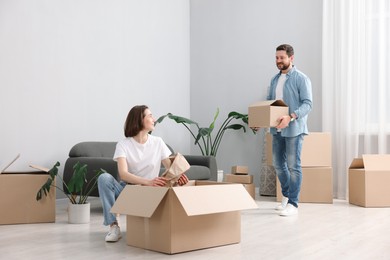 Moving day. Happy couple unpacking their belongings in new home