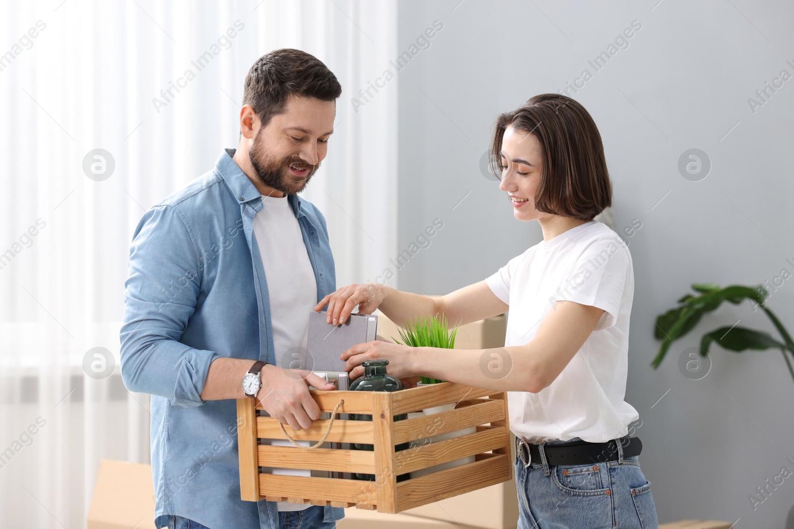 Photo of Moving day. Happy couple unpacking in their new home