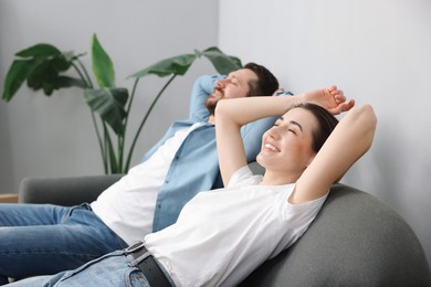 Photo of Moving day. Happy couple resting on couch in their new home, selective focus