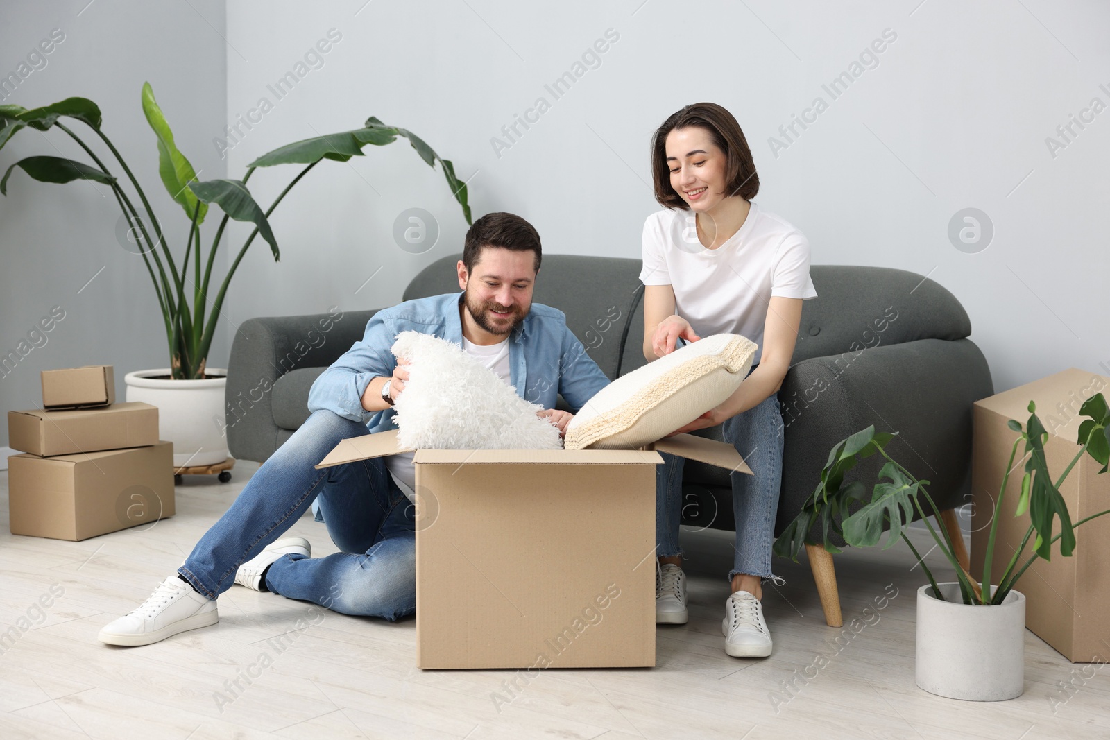 Photo of Moving day. Happy couple unpacking their belongings in new home