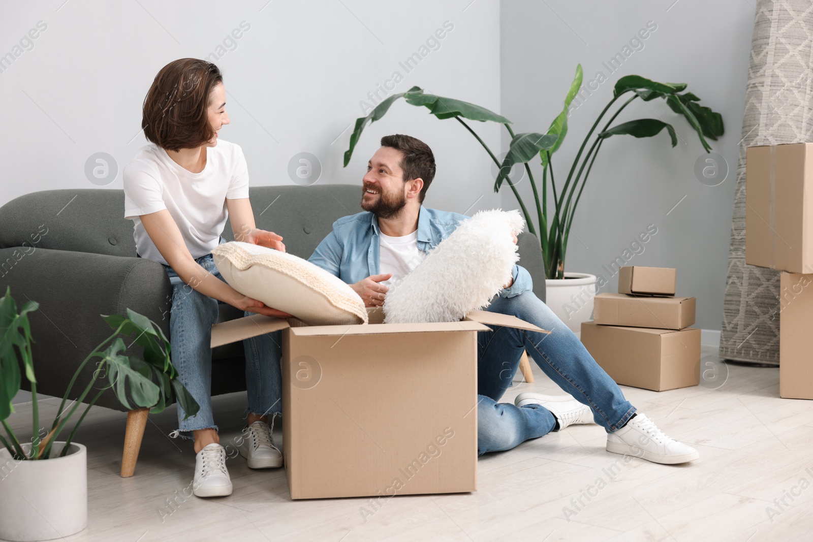 Photo of Moving day. Happy couple unpacking their belongings in new home