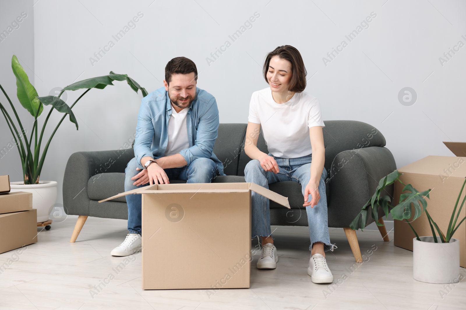 Photo of Moving day. Happy couple unpacking their belongings in new home