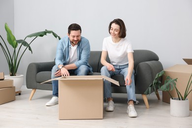 Photo of Moving day. Happy couple unpacking their belongings in new home