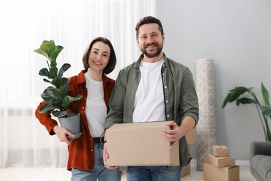 Photo of Moving day. Happy couple with their belongings in new home