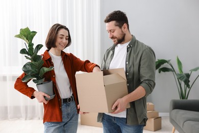 Photo of Moving day. Happy couple with their belongings in new home