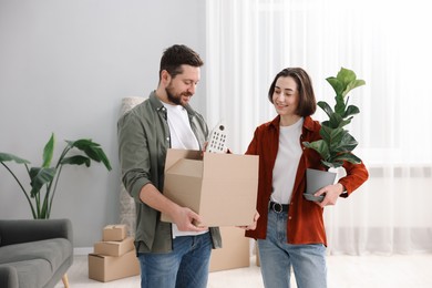 Photo of Moving day. Happy couple with their belongings in new home