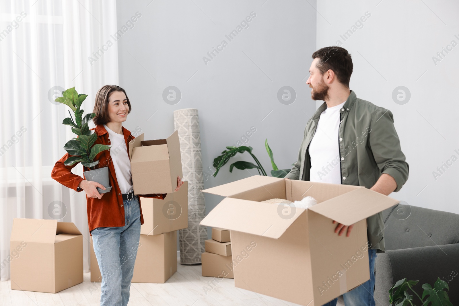 Photo of Moving day. Happy couple with their belongings in new home