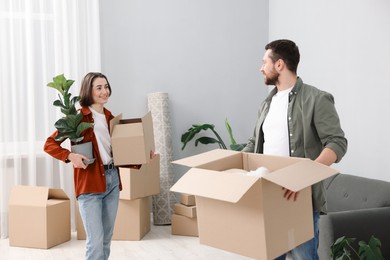 Photo of Moving day. Happy couple with their belongings in new home