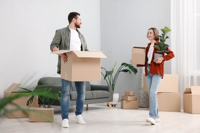 Photo of Moving day. Happy couple with their belongings in new home