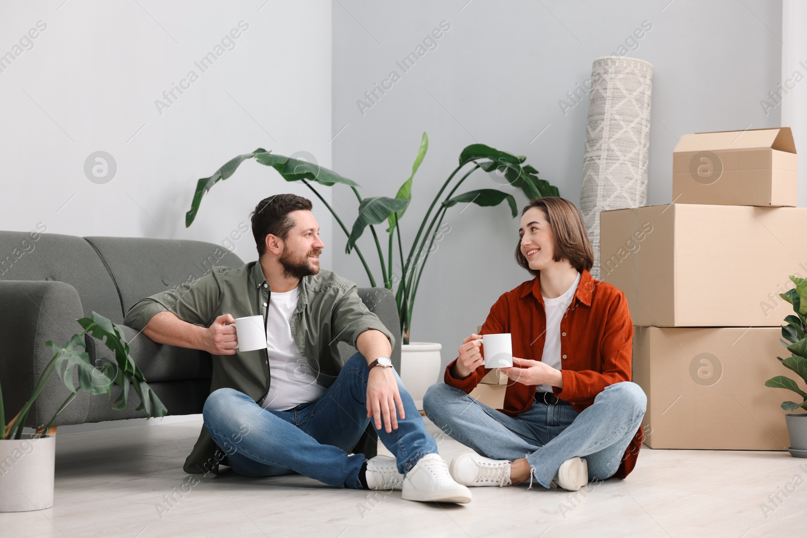 Photo of Moving day. Happy couple with coffee in their new home