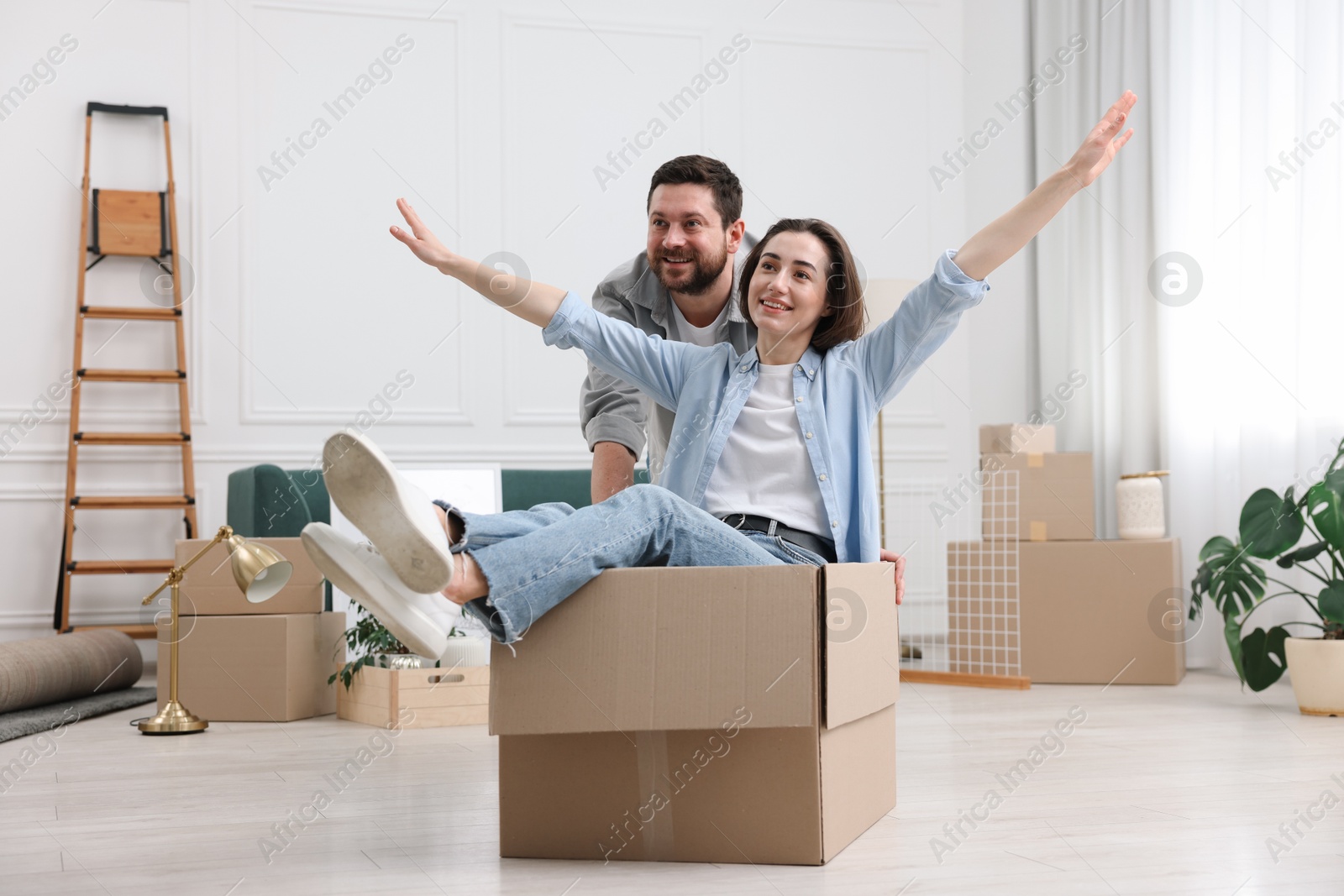 Photo of Moving day. Happy couple having fun in their new home