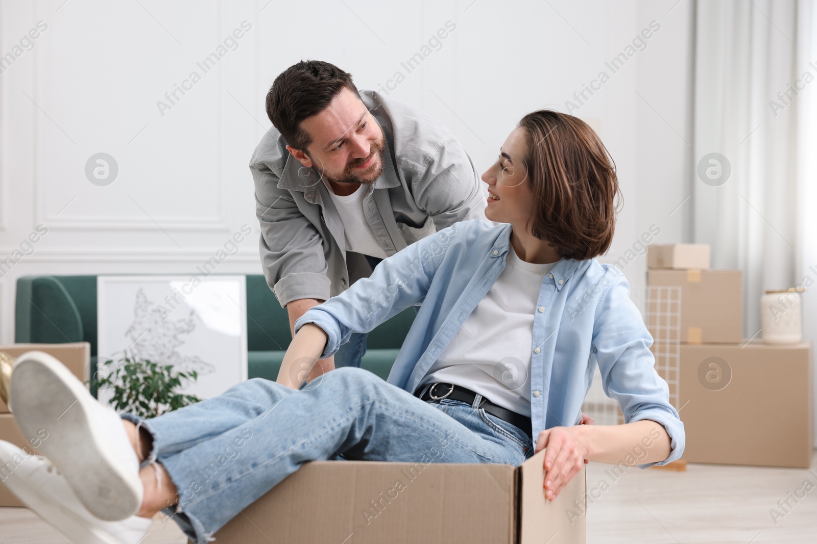 Photo of Moving day. Happy couple having fun in their new home