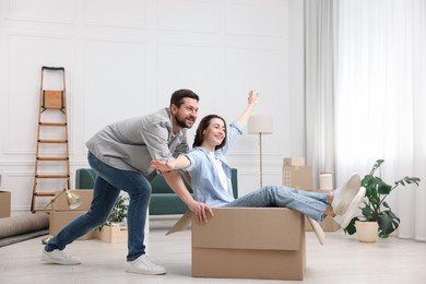 Photo of Moving day. Happy couple having fun in their new home