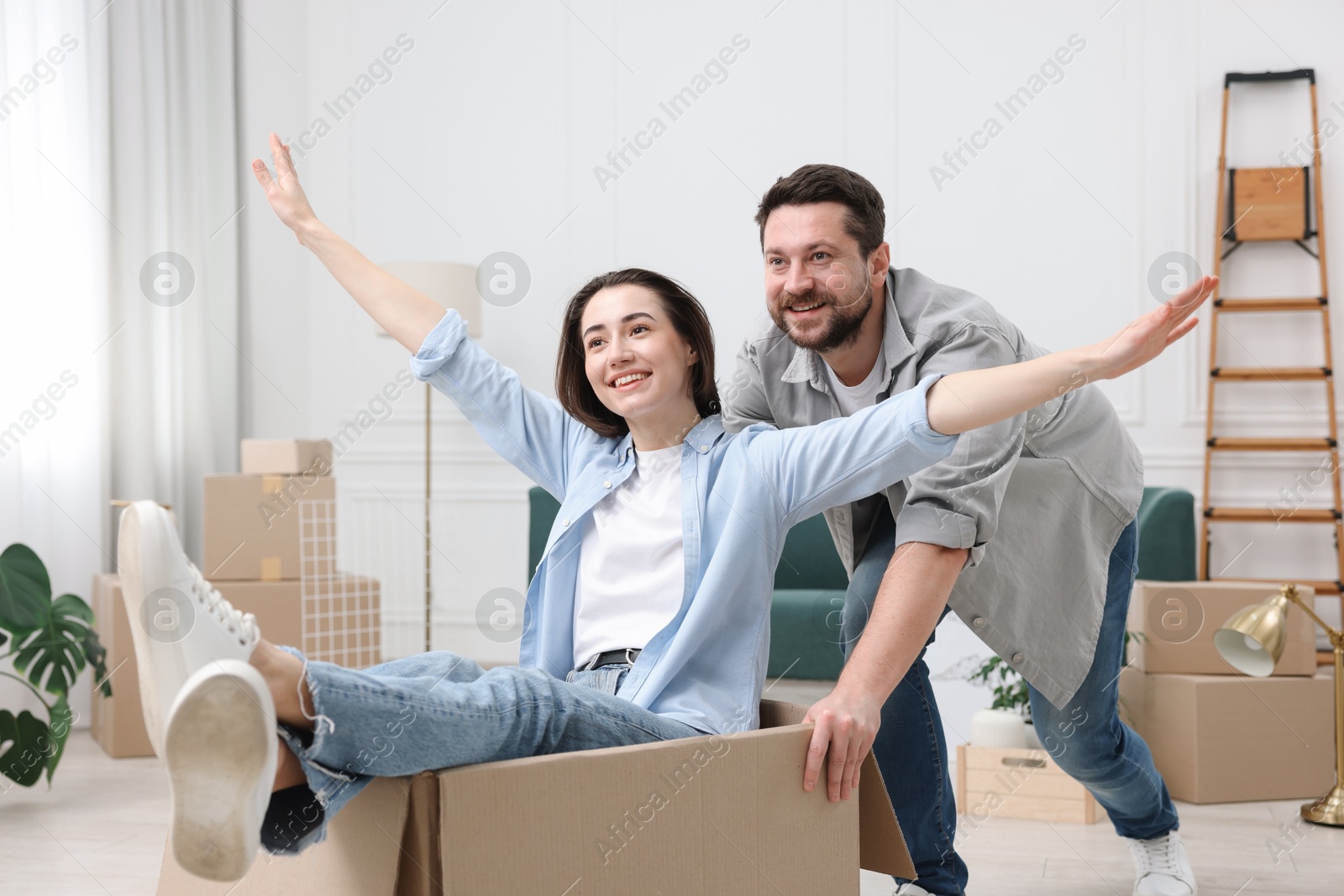 Photo of Moving day. Happy couple having fun in their new home