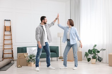 Moving day. Happy couple dancing in their new home