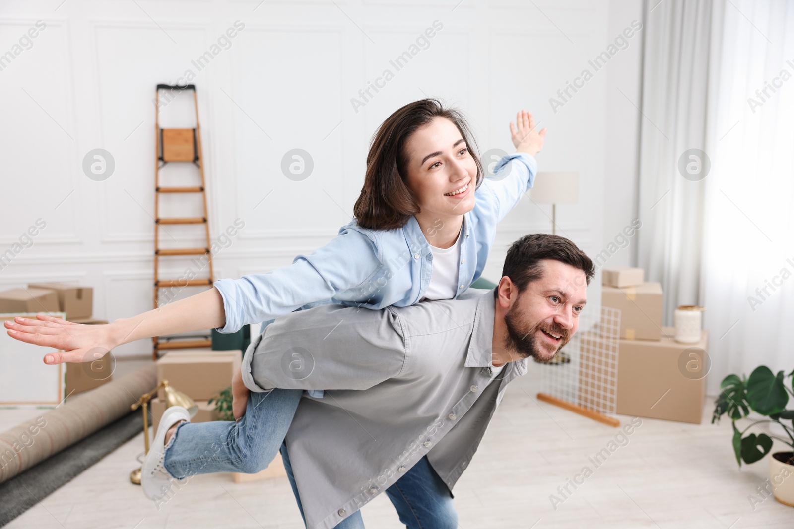 Photo of Moving day. Happy couple having fun in their new home