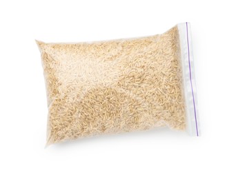 Photo of Raw brown rice in plastic bag isolated on white, top view