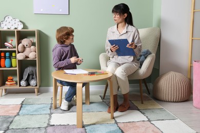 Psychologist evaluating boy's cognitive functions in office