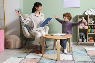 Photo of Psychologist evaluating boy's cognitive functions in office