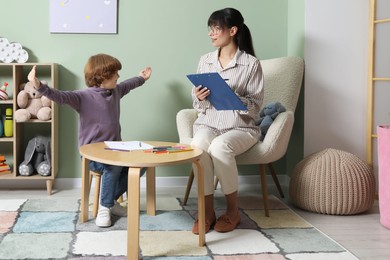 Psychologist evaluating boy's cognitive functions in office