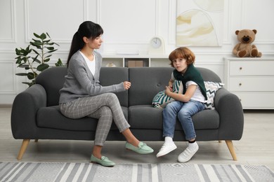 Photo of Little boy having therapy session with psychologist in office