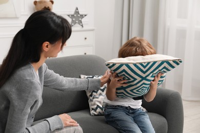 Photo of Upset little boy having therapy session with psychologist in office